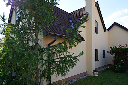 Großes Wohnhaus mit sanierter Fassade in sehr hellem Gelborange