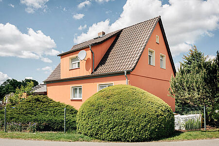 Einfamilienhaus mit frischer Fassade in strahlendem Orange