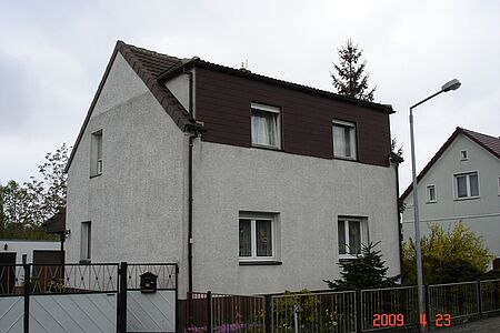 Ehemals weißes Wohnhaus mit stark ergrauter Fassade