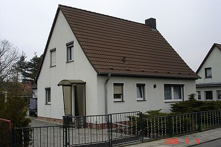 Hellgraues Einfamilienhaus vor der Fassadensanierung 