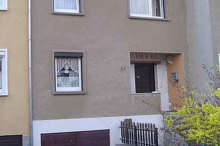 Schmales Reihenhaus mit brauner Fassade vor der Sanierung