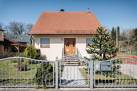Kleines Wohnhaus mit sehr heller rosaner Fassade 