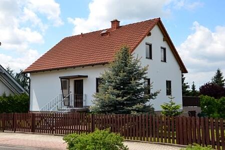 Weißes Einfamilienhaus nach der Sanierung mit Spezialputzfassaden