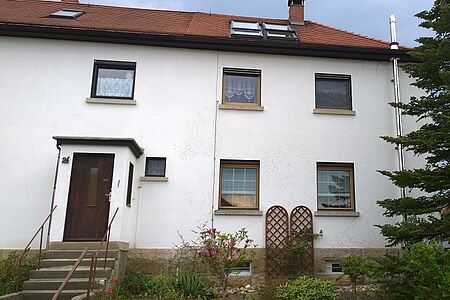 Weißes Reihenhaus mit fleckiger Fassade