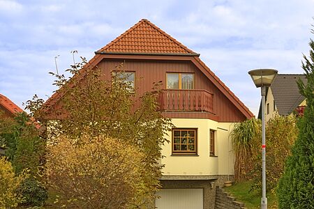 Haus mit Holzelementen und gelber Fassade