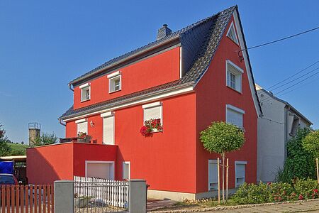 Knallig rotes Haus mit spitzem Satteldach