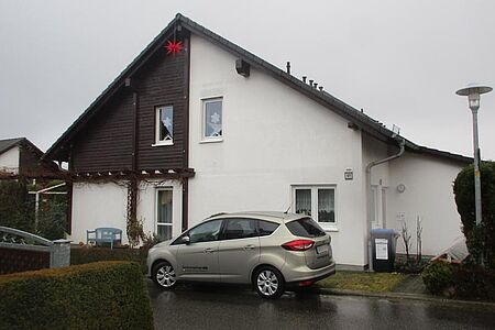 Weißes Wohnhaus mit dunkelbraunen Holzelementen