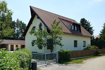 Wohnhaus mit spitzem Dach und mintgrüner Fassade