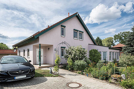 Großes, rosanes Wohnhaus im Grünen