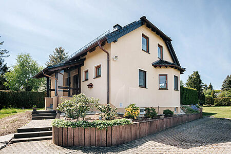 Einfamilienhaus mit ebenmäßiger Fassade in sehr hellem Pastellorange