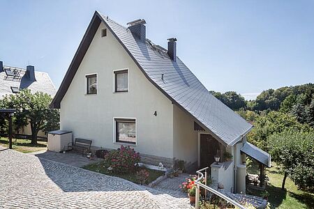 Weißes Wohnhaus mit überdachtem Eingangsbereich