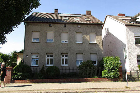Reihenhaus mit grau-braun verputzter Fassade
