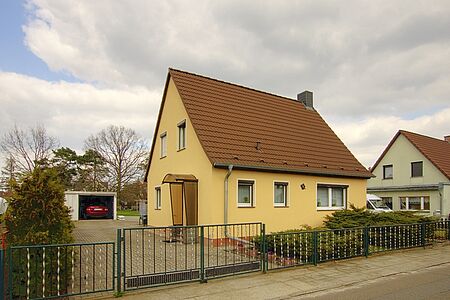 Hellgelbes Einfamilienhaus mit ebenmäßiger FBS Fassadenbeschichtung
