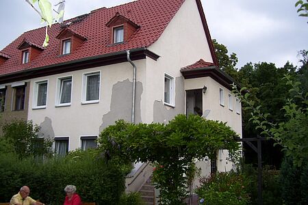 Weiße Doppelhaushälfte mit grauen Flecken auf der Fassade
