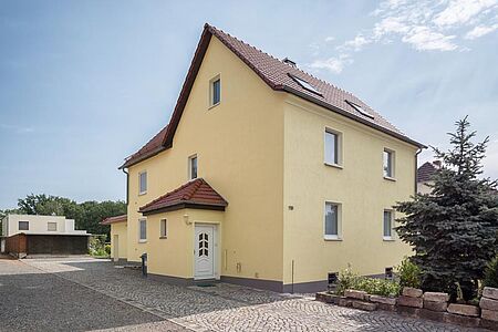 Großes Wohnhaus mit hellgelben Spezialputzfassaden