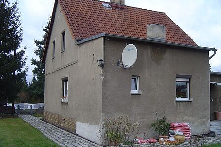 Braunes Wohnhaus mit Vordach und alter Fassade