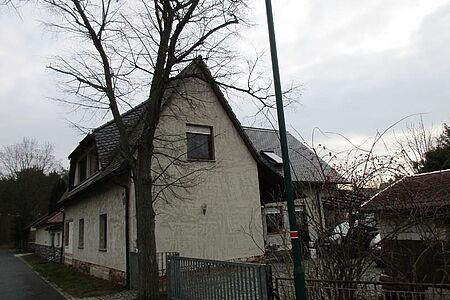 Schmales Einfamilienhaus mit heller, verwitterter Fassade