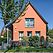 Haus mit orangener Fassade und hellblauen Fensterrahmen