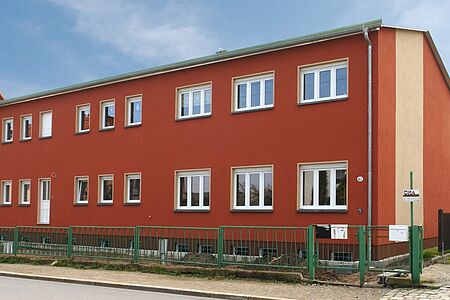 Wohnhaus mit drei Stockwerken in hellem Gelb