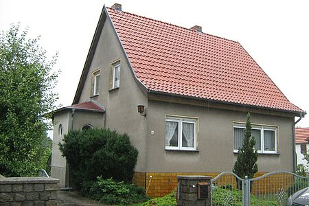 Ungestrichenes Einfamilienhaus mit grau-braunem Putz