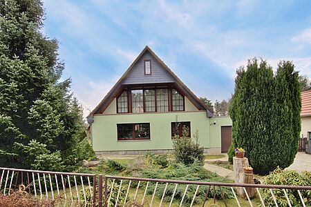 Wohnhaus mit ebenmäßiger, pastellgelber Fassade nach der Sanierung
