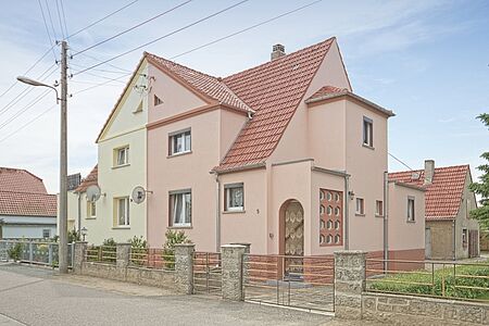 Doppelhaus mit Fassade in Hellgrün und Rosa