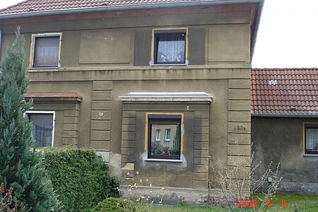 Haus mit Walmdach und veralteter Fassade