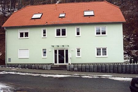 Neubau eines mintgrünen Vierfamilienhauses