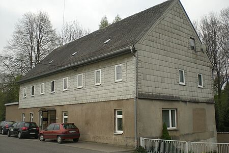 Mehrfamilienhaus mit verputztem unteren Stockwerk und Vertäfelung