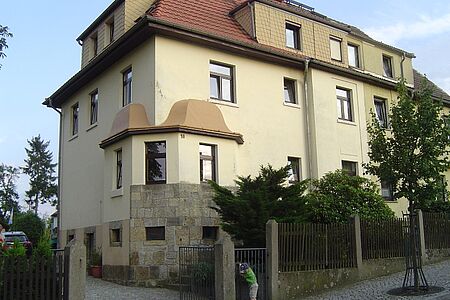 Villa mit drei Stockwerken und hellbeiger Fassade
