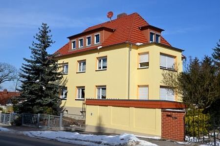 Dreistöckiges Mehrfamilienhaus mit frischer Fassade in ebenmäßigem Gelb
