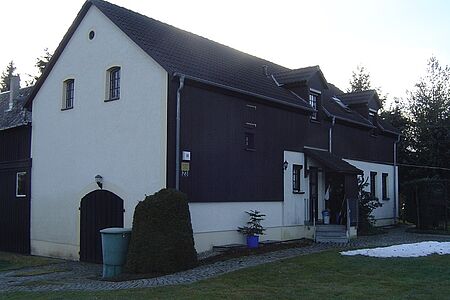 Landhaus mit sanierungsbedürftiger Fassade in Weiß und Schwarz