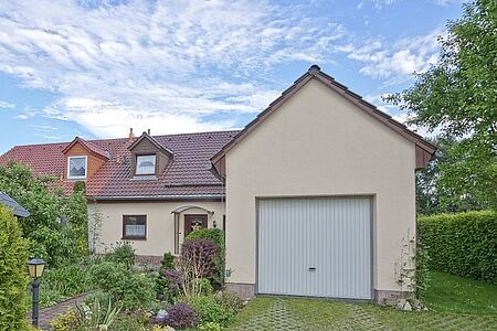 Einfamilienhaus mit angebauter Garage und ebenmäßiger FBS Fassadenbeschichtung in Eierschalenweiß