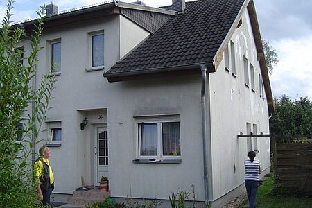 Weißes Reihenhaus mit Stockflecken auf der Fassade