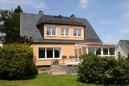 Oranges Wohnhaus mit Garten, Wintergarten und frischem Anstrich