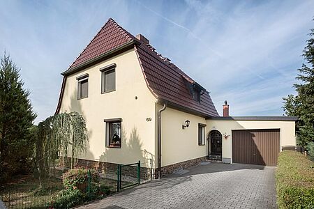 Einfamilienhaus mit Garage und Fassade in hellem Gelb