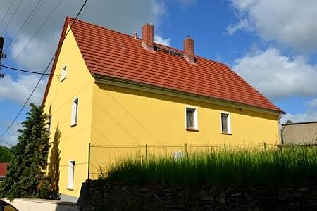 Mehrfamilienhaus mit sonnengelber Fassade