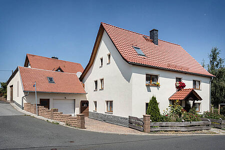 Wohnhaus mit Garage und frischer, eierschalenweißer Fassade 