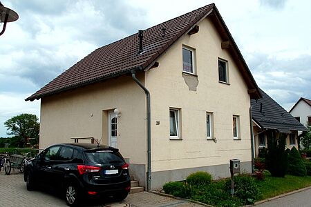 Beschädigte Hauswand eines Einfamilienhaus, teils offener Blick auf Rohbau