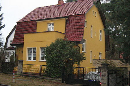 Orangenes Haus mit Mansardendach