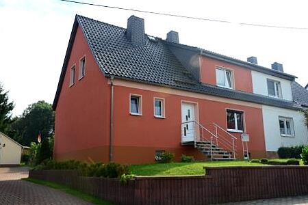 Doppelhaus mit Fassade in dunklem Orange und hellem Blau