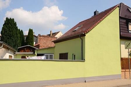 Gelbgrüne Mauer und Hausfassade inklusive Blick auf Innenhof