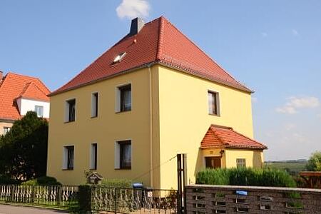 Mehrfamilienhaus nach der Fassadensanierung mit gelbem Anstrich