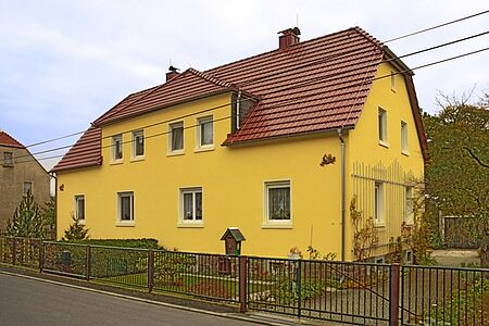 Gelbes Zweifamilienhaus mit Garten