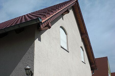 Außenansicht auf zwei geschlossene Fenster mit heruntergelassenen Jalousien