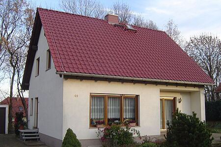 Einfamilienhaus mit weißer Fassade im Grünen