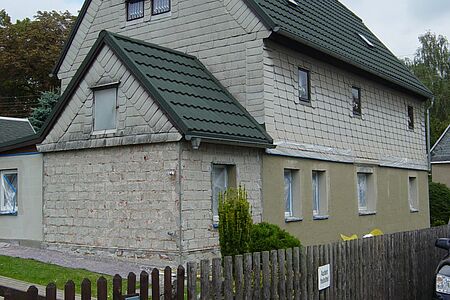 Verklinkertes und vertäfeltes Haus mit einer verputzen Wand