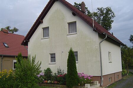 Einfamilienhaus mit stark verschmutzter, ehemals weißer Fassade