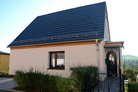 Einfamilienhaus mit sanierter, pastelloranger Fassade
