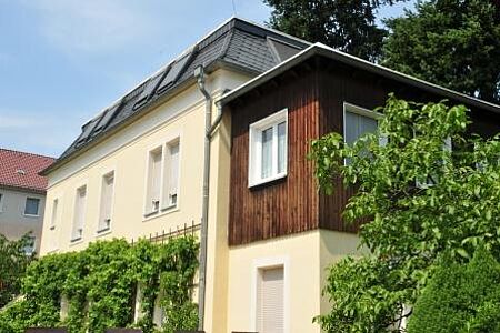 Mehrfamilienhaus mit Spezialputzfassade in strahlendem Pastellgelb
